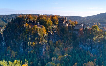Blick auf eine Burgruine und das Kloster Oybin mitten im Zittauer Gebirge.