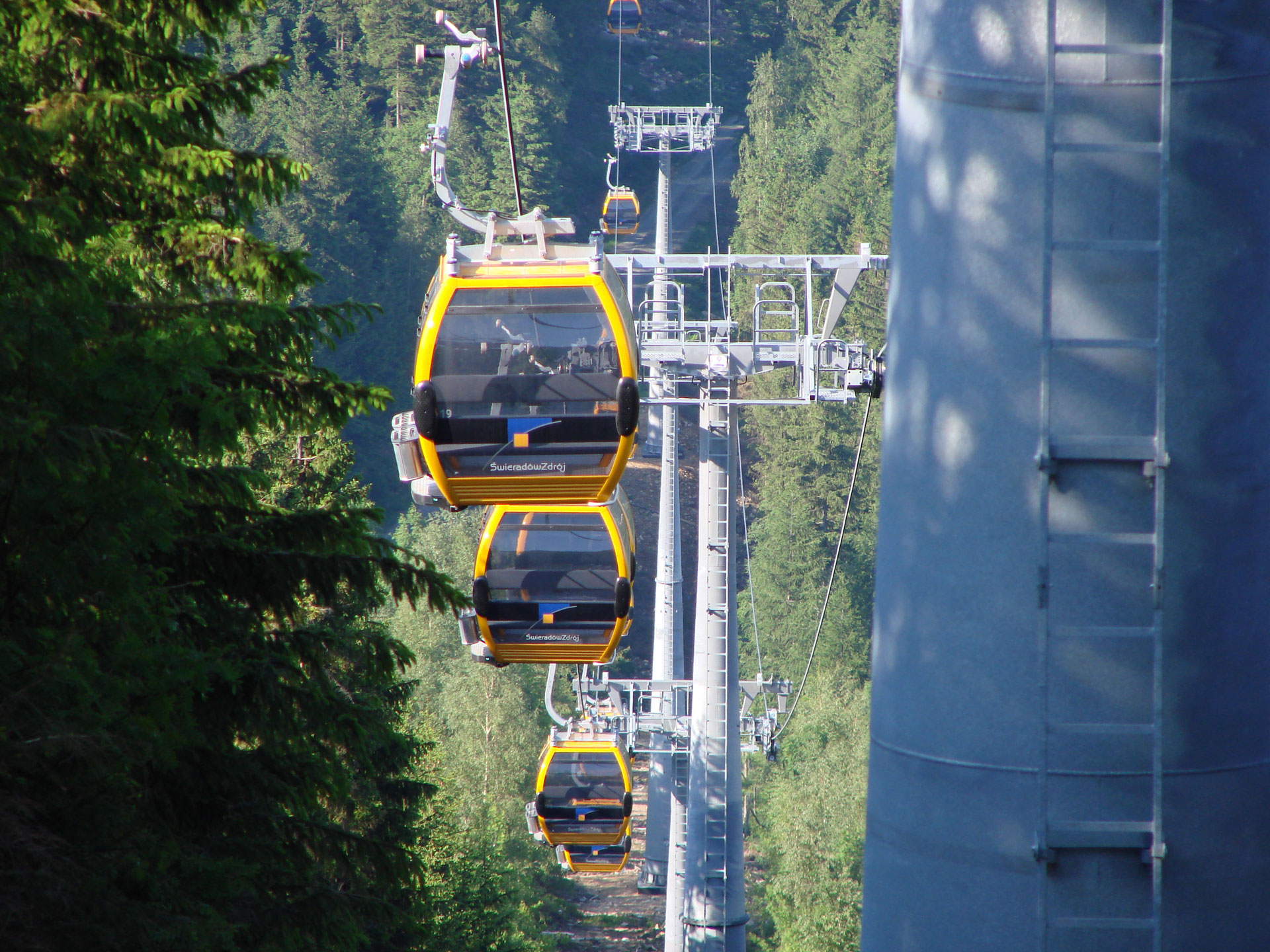 Die Gondelbahn mit mehreren Gondeln am steilen Hang.