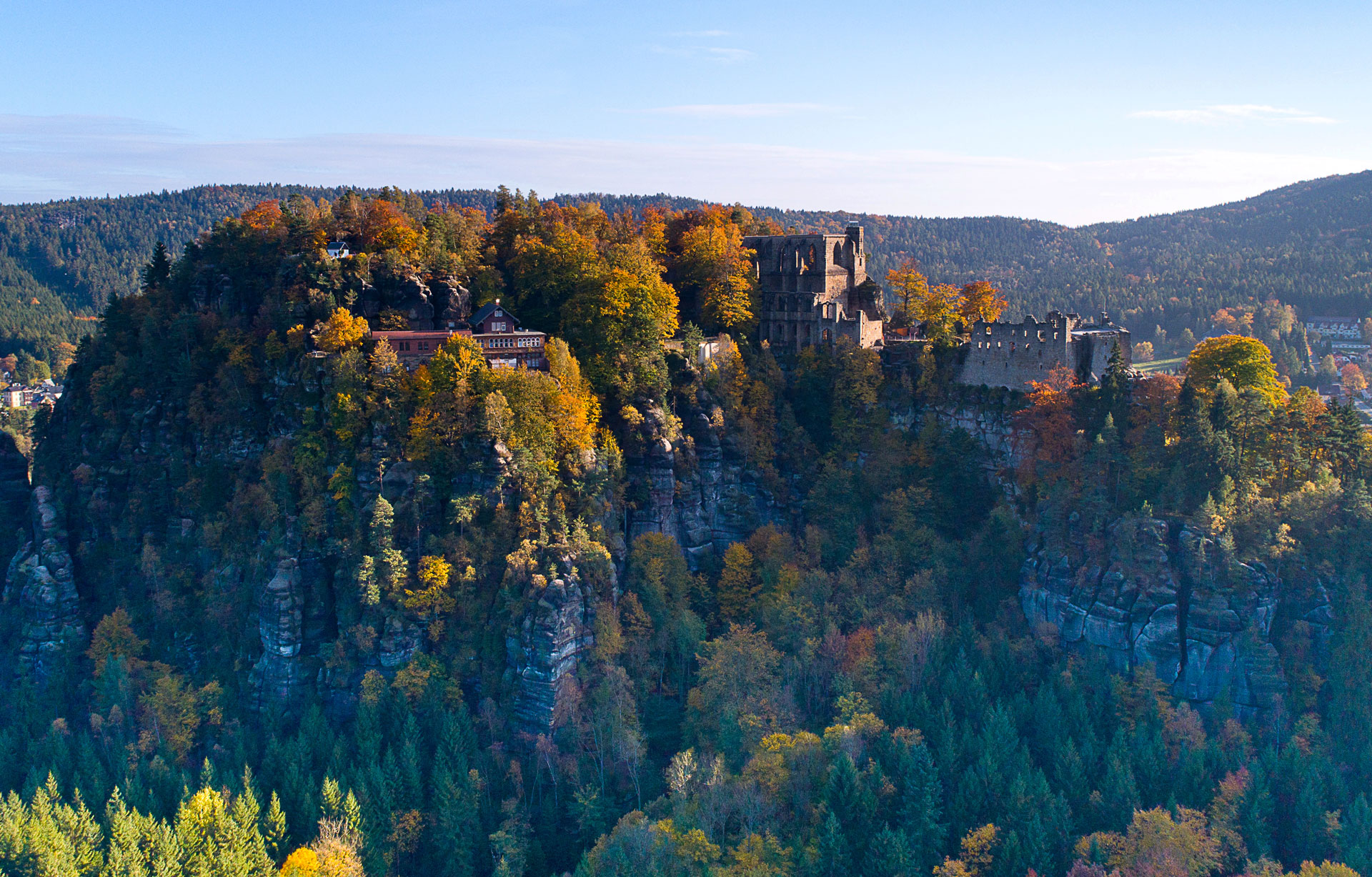 Blick auf eine Burgruine und das Kloster Oybin mitten im Zittauer Gebirge.